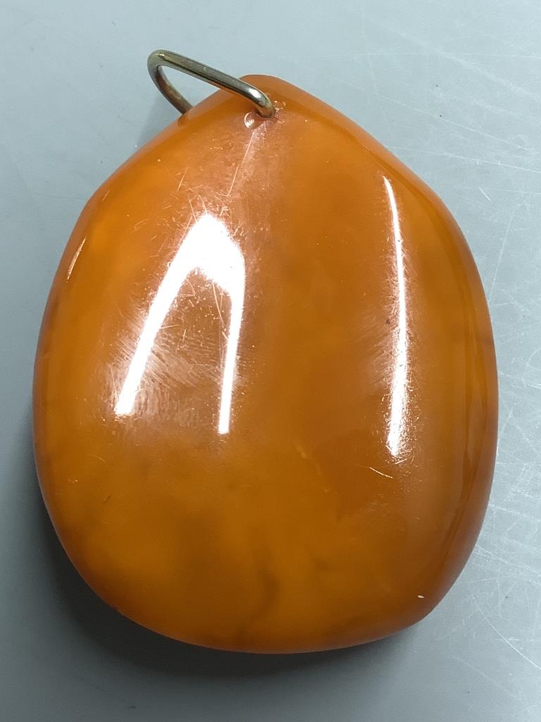 An amber pebble pendant, 56mm, gross weight 29.5 grams.